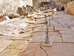 הרחוב המרוצף ושרידי החנויות (משמאל) בקטע הצפוני שנחשף, בגן הארכיאולוגי ירושלים